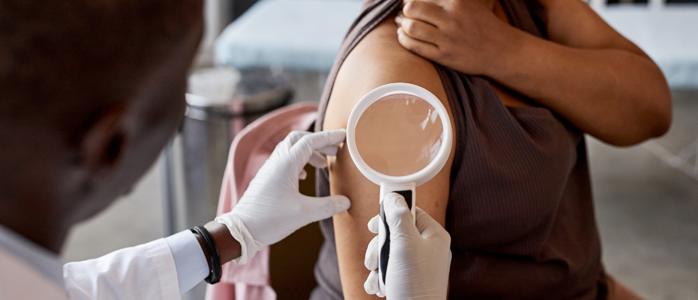 Patient consulting dermatologist during skin exam.