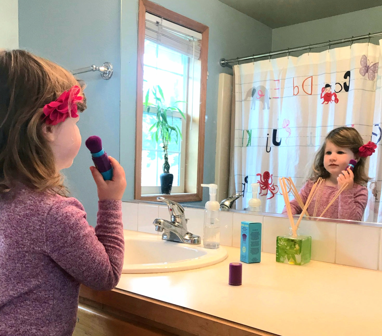 BRUSH ON BLOCK® image of girl applying BOB KIDS in bathroom mirror.