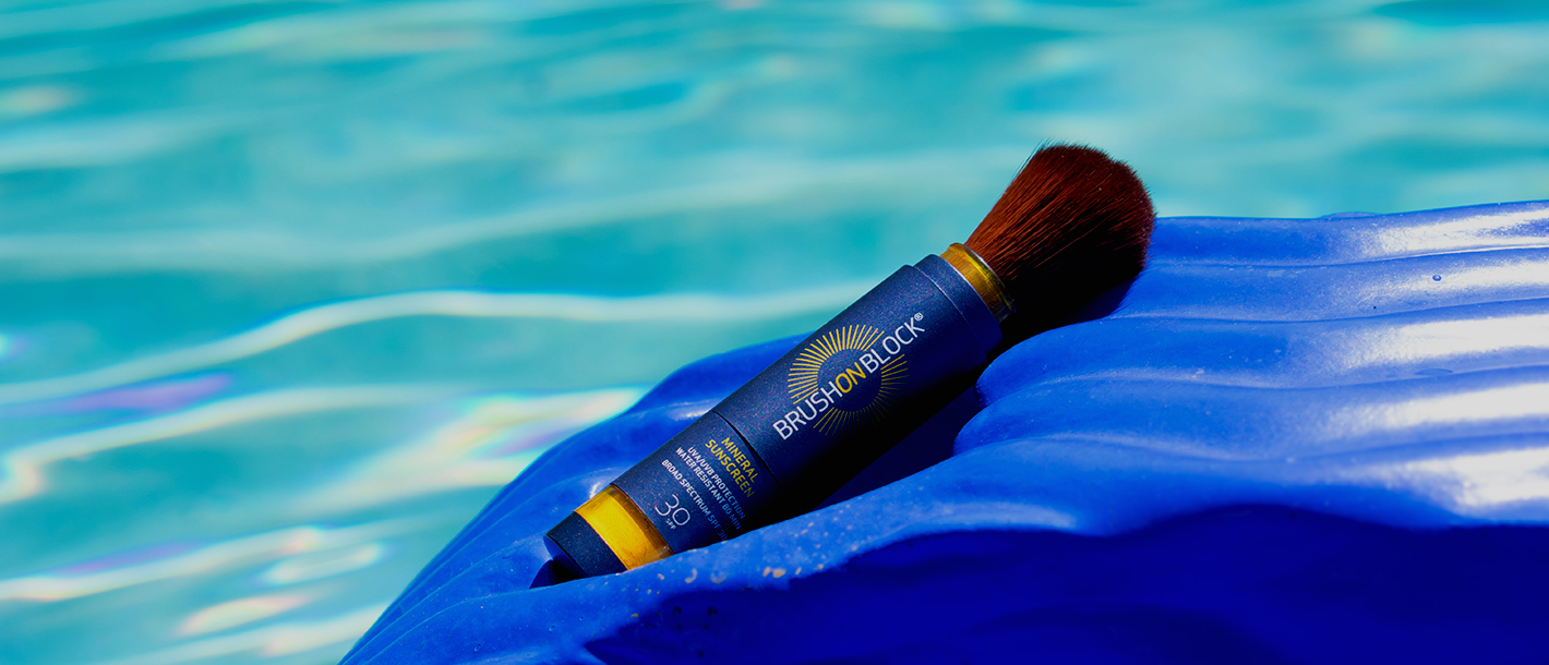Brush On Block Mineral Powder Sunscreen on a pool float in a pool.