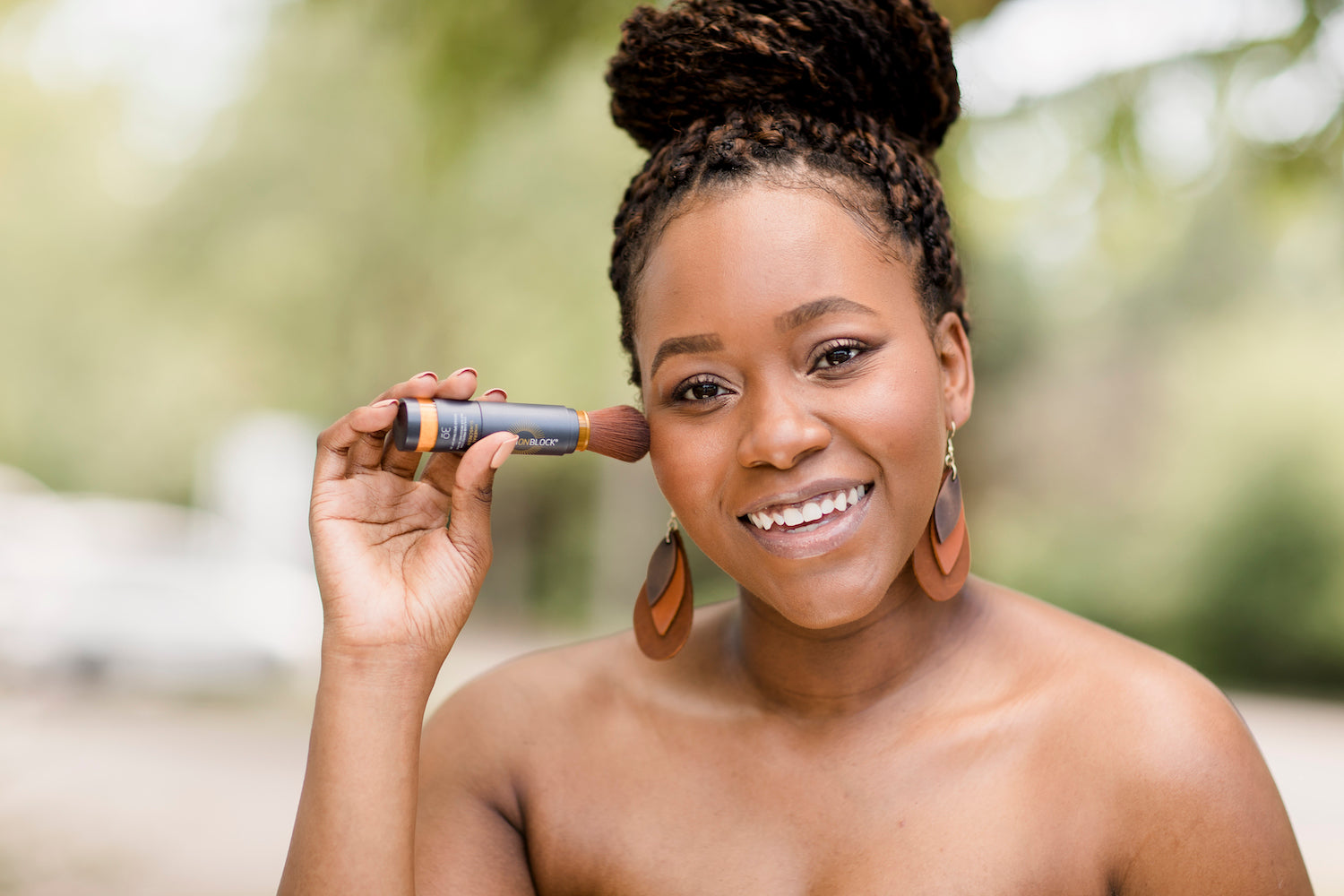 Woman Applying Brush On Block® Natural Powder Sunscreen 