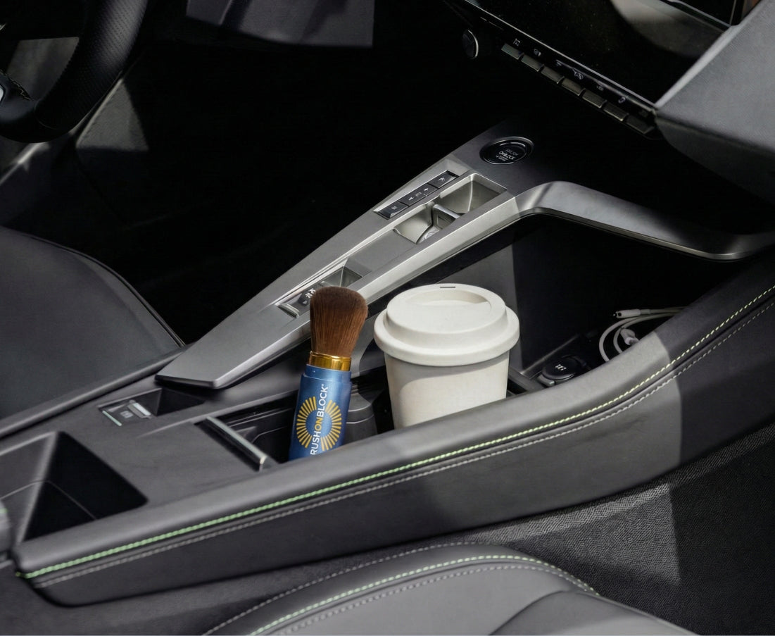 Car cup holder with a coffee cup and Brush On Block mineral demonstrating easy sunscreen portability and reapplication.