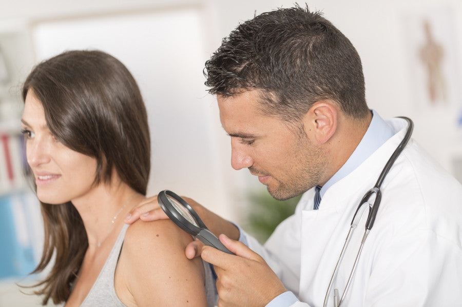 Brush On Block image of doctor examining mole on woman's shoulder