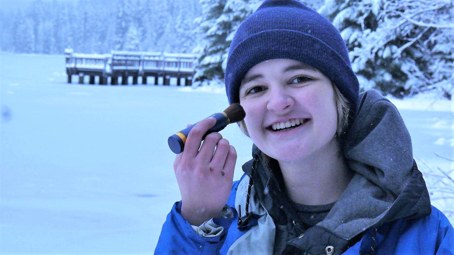 Brush On Block® image of woman applying Brush On Block in snow.