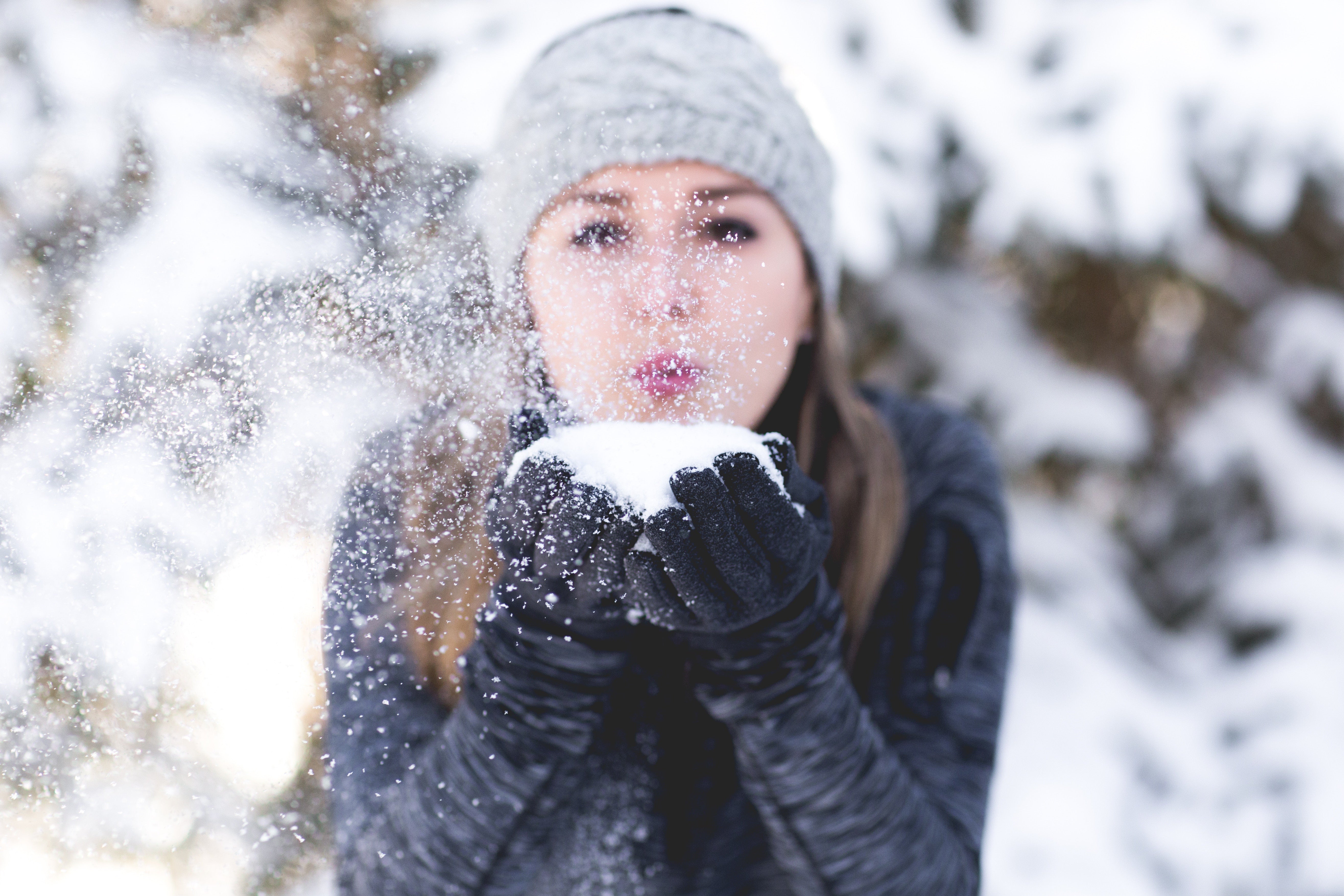 Brush On Block image of girl blowing handful of snow at camera