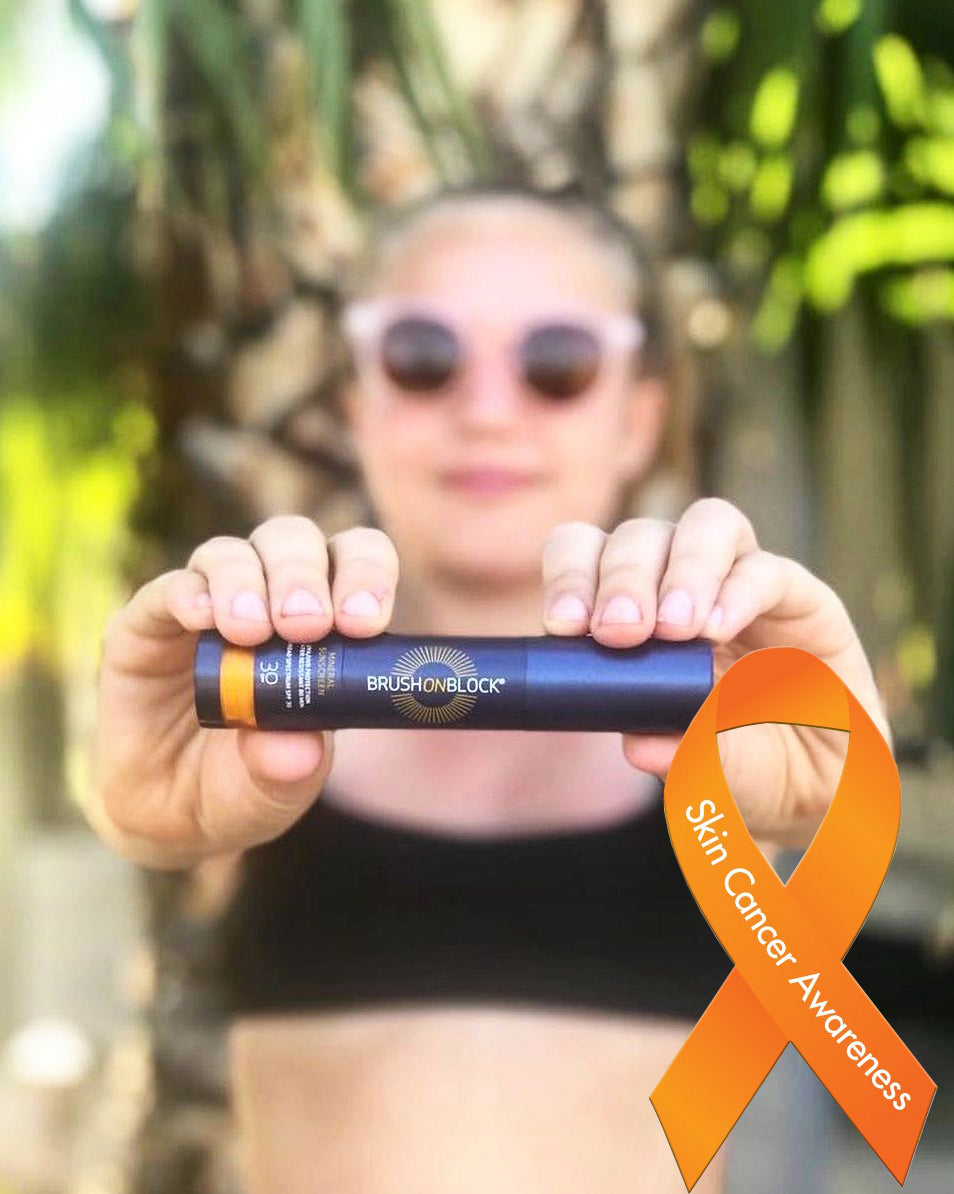 girl holding BRUSH ON BLOCK with Skin Cancer Awareness ribbon.
