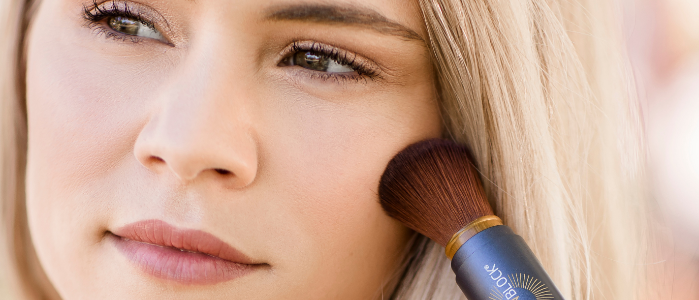 Woman applying Brush On Block mineral powder sunscreen SPF 30 with brush applicator, mineral sun protection for acne-prone skin