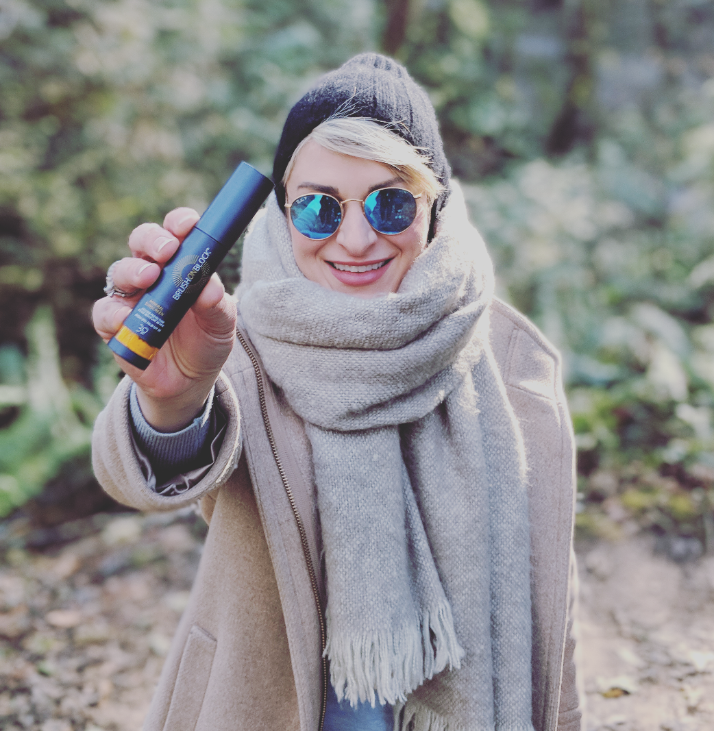 Dr. Lauren Boudreaux holding Brush On Block SPF 30 Mineral Powder sunscreen.