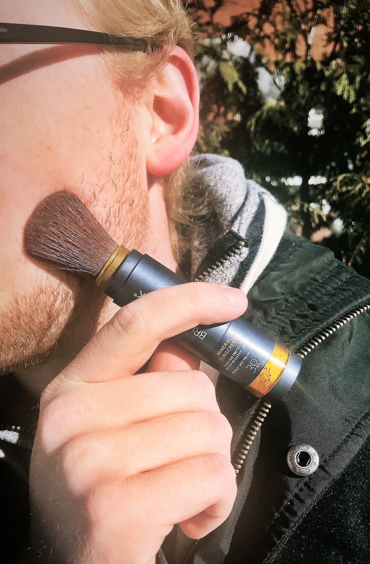 Man applying Brush On Block to his face.