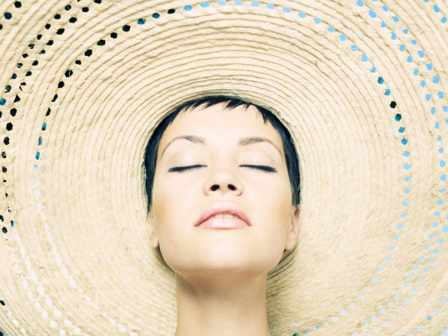Brush On Block image of woman with closed eyes in a huge hat