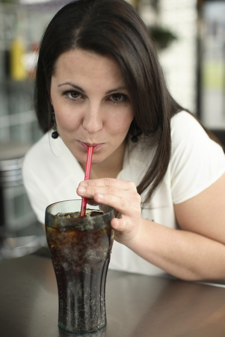 Brush On Block image of woman drinking soda through a straw