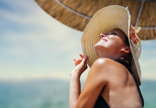 Woman at Beach Using Brush On Block Mineral Sunscreen