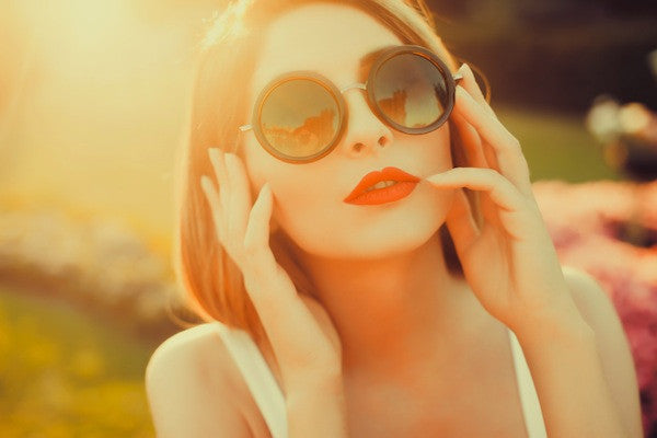 Brush On Block image of woman with red lipstick and sunglasses in the sunlight