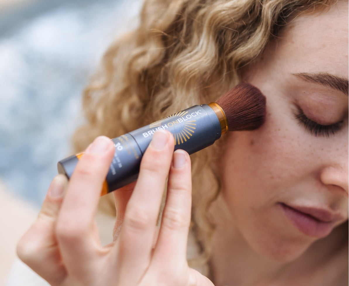 Woman applying Brush On Block SPF 30